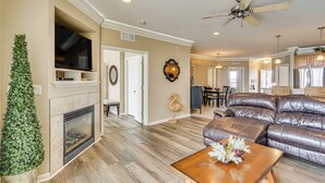 A spacious living room with a fireplace, leather sofa, and a dining area in the background. - Resort Perks, View: Lands End Condo in Osage Beach (Osage Beach)