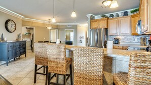 A spacious kitchen with a central island, wooden cabinets, and hanging pendant lights. - Resort Perks, View: Lands End Condo in Osage Beach (Osage Beach)