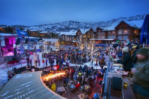 A crowded outdoor market with wooden buildings and snow-covered mountains in the background. - New Luxury Aspen Home by Aspen Vacation Rentals™ (Aspen)