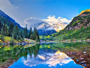 A mountain landscape with a clear lake reflecting the scenery. - New Luxury Aspen Home by Aspen Vacation Rentals™ (Aspen)
