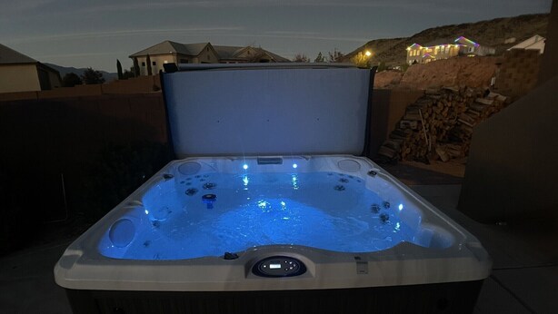 A hot tub with a control panel and a view of a residential area in the background.