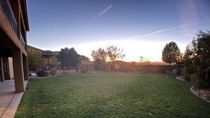 A well-maintained lawn with a clear sky and distant trees.