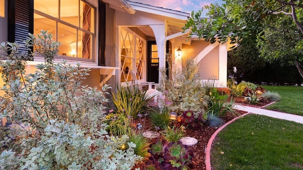 A modern house with a covered porch, large windows, and a well-maintained garden with various plants and a pathway. -  PICTURE PERFECT minutes to UNIVERSAL STUDIOS & HOLLYWOOD: Rated 10/10!!! (Los Angeles)