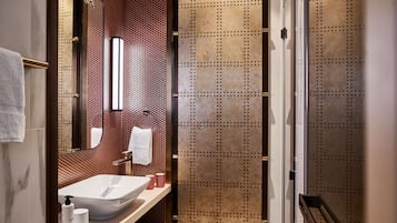 Een badkamer met een wit wastafel, een spiegel en een handdoekhouder.