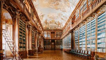 Een statige bibliotheek met sierlijk houtwerk, hoge plafonds en uitgebreide boekencollecties.