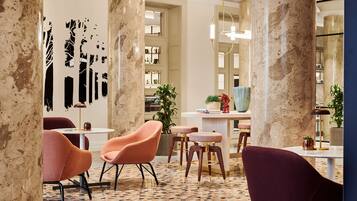 A modern interior with marble columns, a patterned floor, and contemporary furniture.