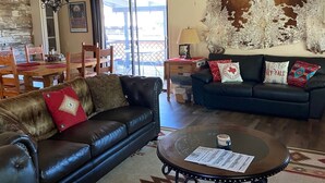 Un salon spacieux avec un canapé en cuir, une table basse et un divan bleu.