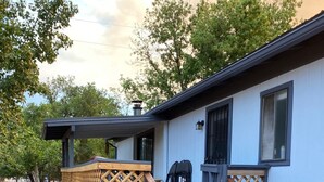 Une maison avec une terrasse en bois, un porche couvert et une cheminée.