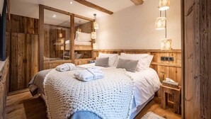 Une chambre confortable avec un grand lit, une tête de lit en bois, un miroir, des lampes de chevet et une petite table de chevet.