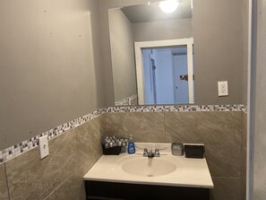 Un baño con un lavamanos blanco, un espejo y un salpicadero de azulejos.
