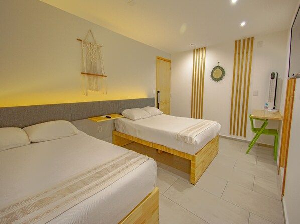 A modern hotel room with two wooden beds, a small desk, and a green chair.