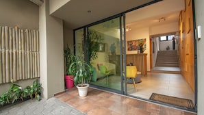 A modern entrance with a glass door, a staircase, and a reception desk. - Capital O Hotel Terraza 158 Mexico City (Mexico City)