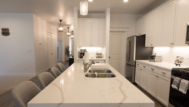 A modern kitchen with a marble countertop, stainless steel appliances, and a central island. - NEW Flagstaff single-story home with a beautiful backyard and Hot Tub! (Flagstaff)