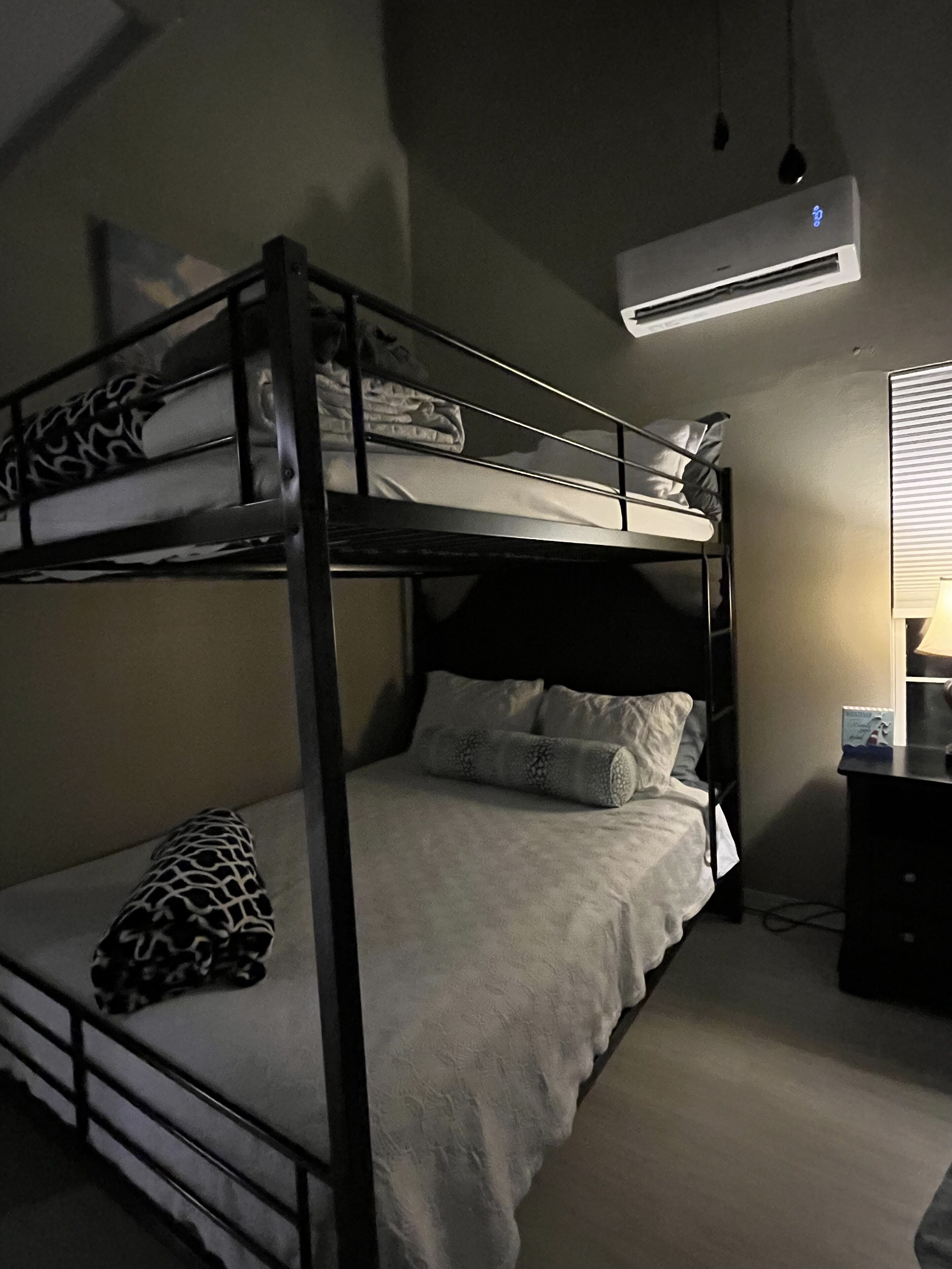 Habitación con literas, escritorio y aire acondicionado.
