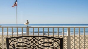 A beach view with a white fence, a flag, and a chair. - Breathtaking Beach Front House - Steps to the Sand (Aptos)