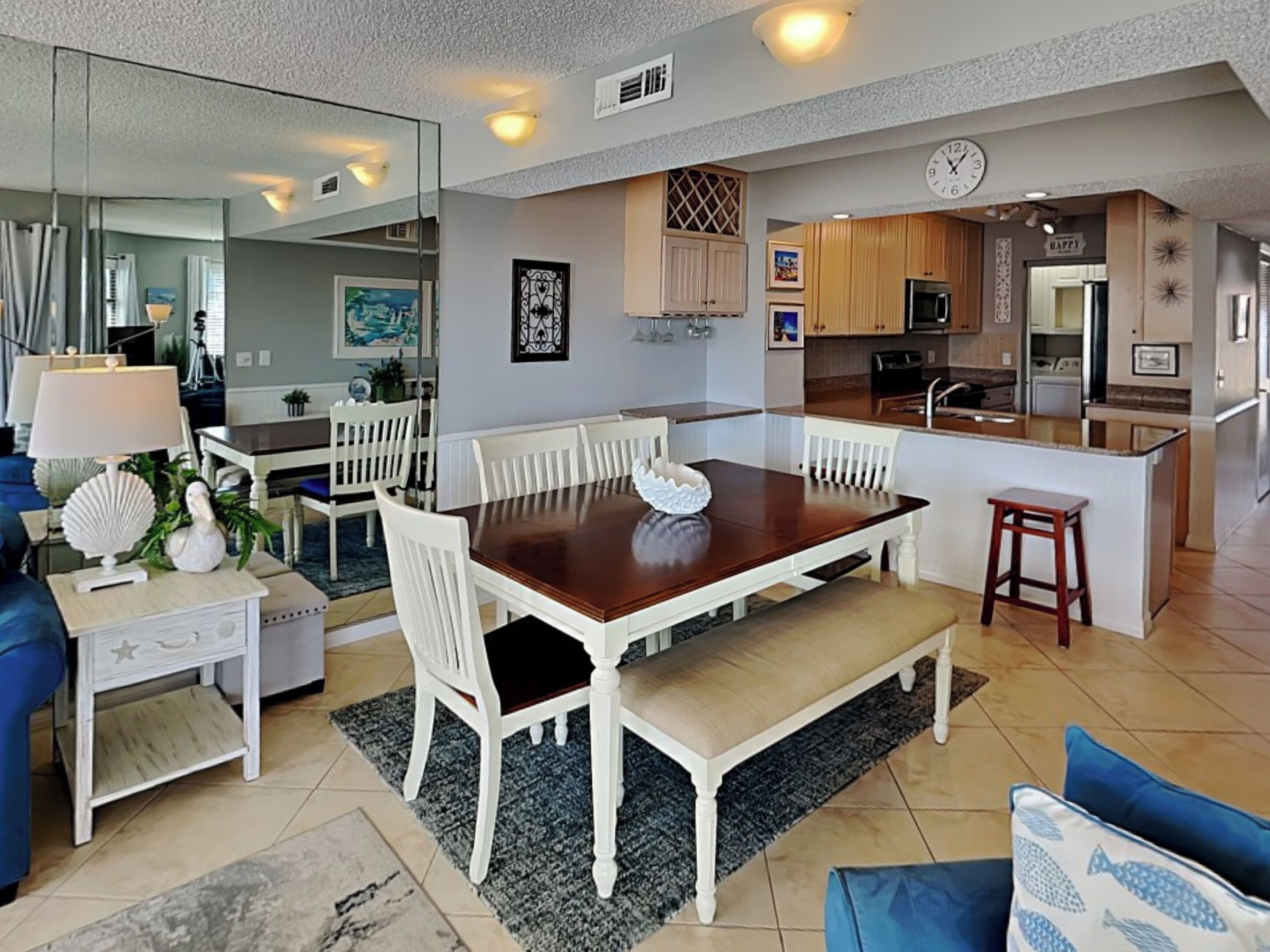 A modern kitchen with wooden cabinets, a built-in island, and a clock on the wall.
