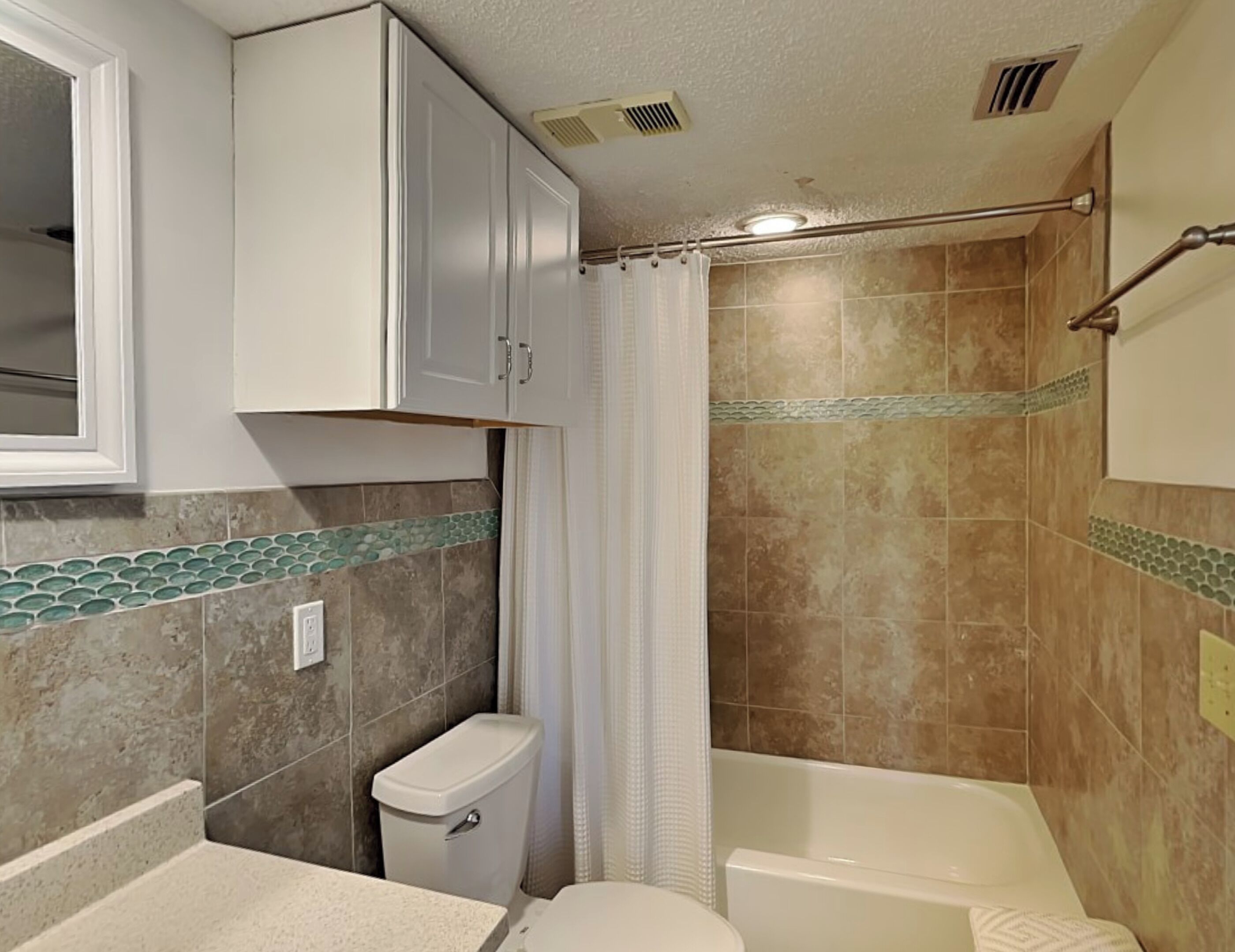 A bathroom with a toilet, sink, bathtub, and shower area.