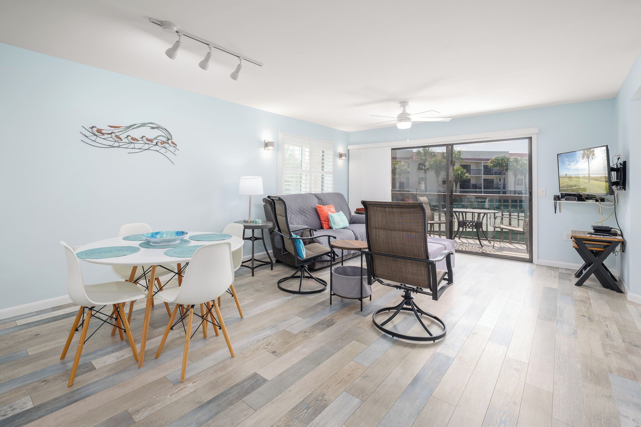 Una sala de estar moderna con comedor, sofá y televisión.