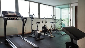 Ein Fitnessraum mit Laufbändern, Ergometer und einer Bank.