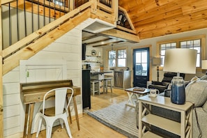 Un intérieur en bois comprenant un escalier, une cuisine et un coin salon.