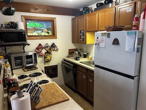 Una cocina equipada con microondas, tostadora, cafetera y refrigerador.