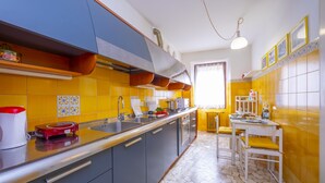 A kitchen with a long countertop, a sink, and a dining area with a table and chairs.