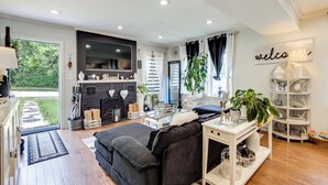 A modern living room with a sofa, TV, fireplace, and a bookshelf. - Butterfly Place-Near Johns Hopkins,Pimlico,Stadium (Baltimore)