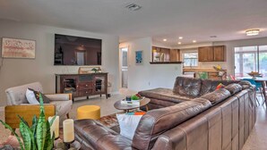 A modern living room with a sectional sofa, a dining area, and a kitchen in the background. - Colorful Fort Myers Home w/ Sunroom & Patio! (Fort Myers)