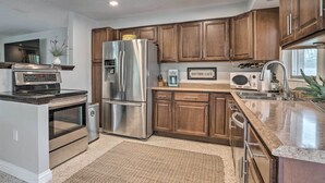 A modern kitchen with stainless steel appliances, wooden cabinets, and a built-in oven. - Colorful Fort Myers Home w/ Sunroom & Patio! (Fort Myers)