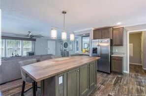 Kitchen features a central island with cabinets, stainless steel appliances, and pendant lighting.
