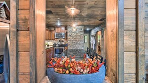 Una cocina con paredes de madera, un detalle en pared de piedra y una isla central con una decoración.