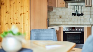 Une cuisine avec des meubles en bois, un pare-feu en carrelage et un four en acier inoxydable.