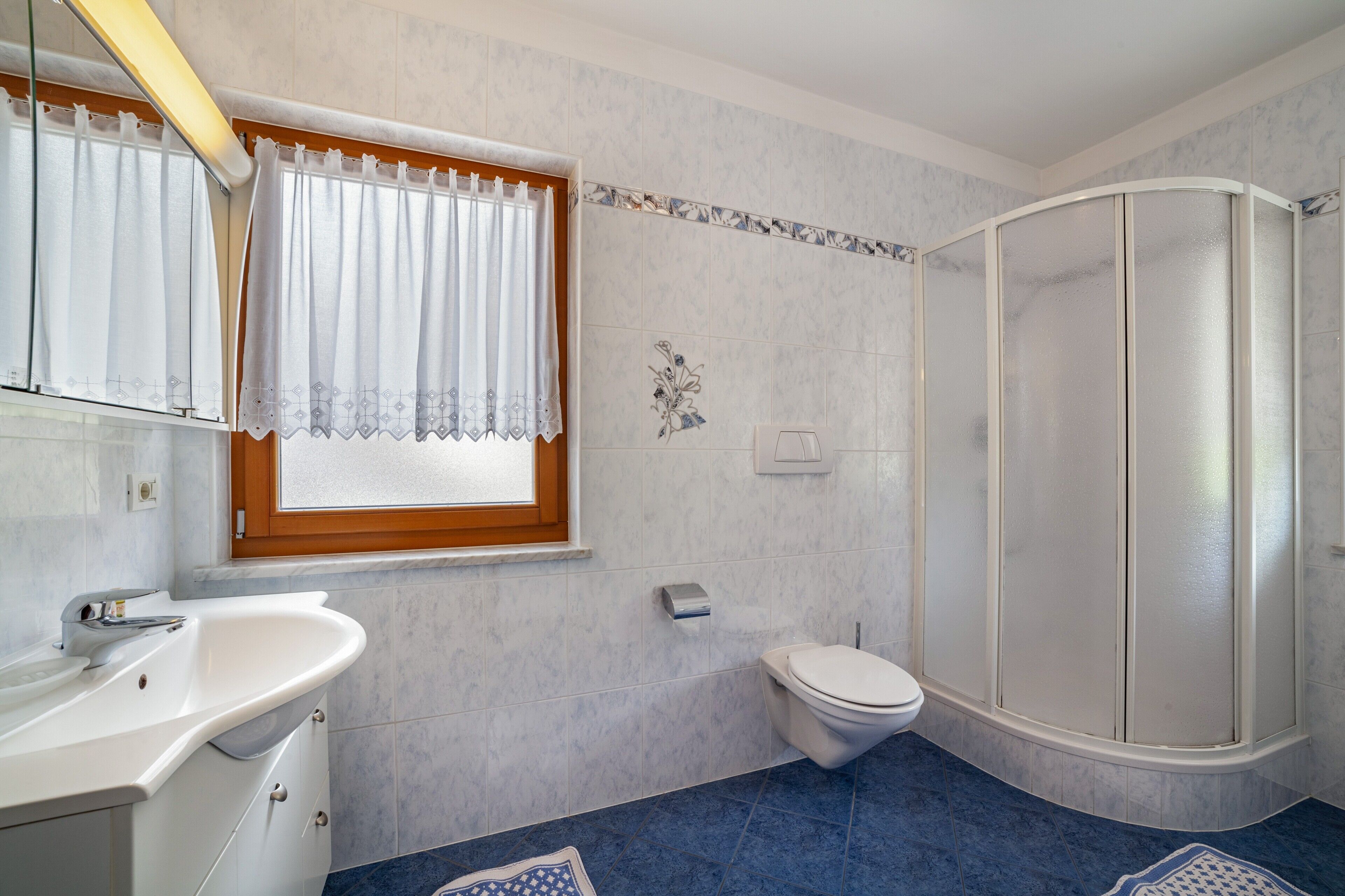 Une salle de bain équipée d’un lavabo, de toilettes et d’une douche.