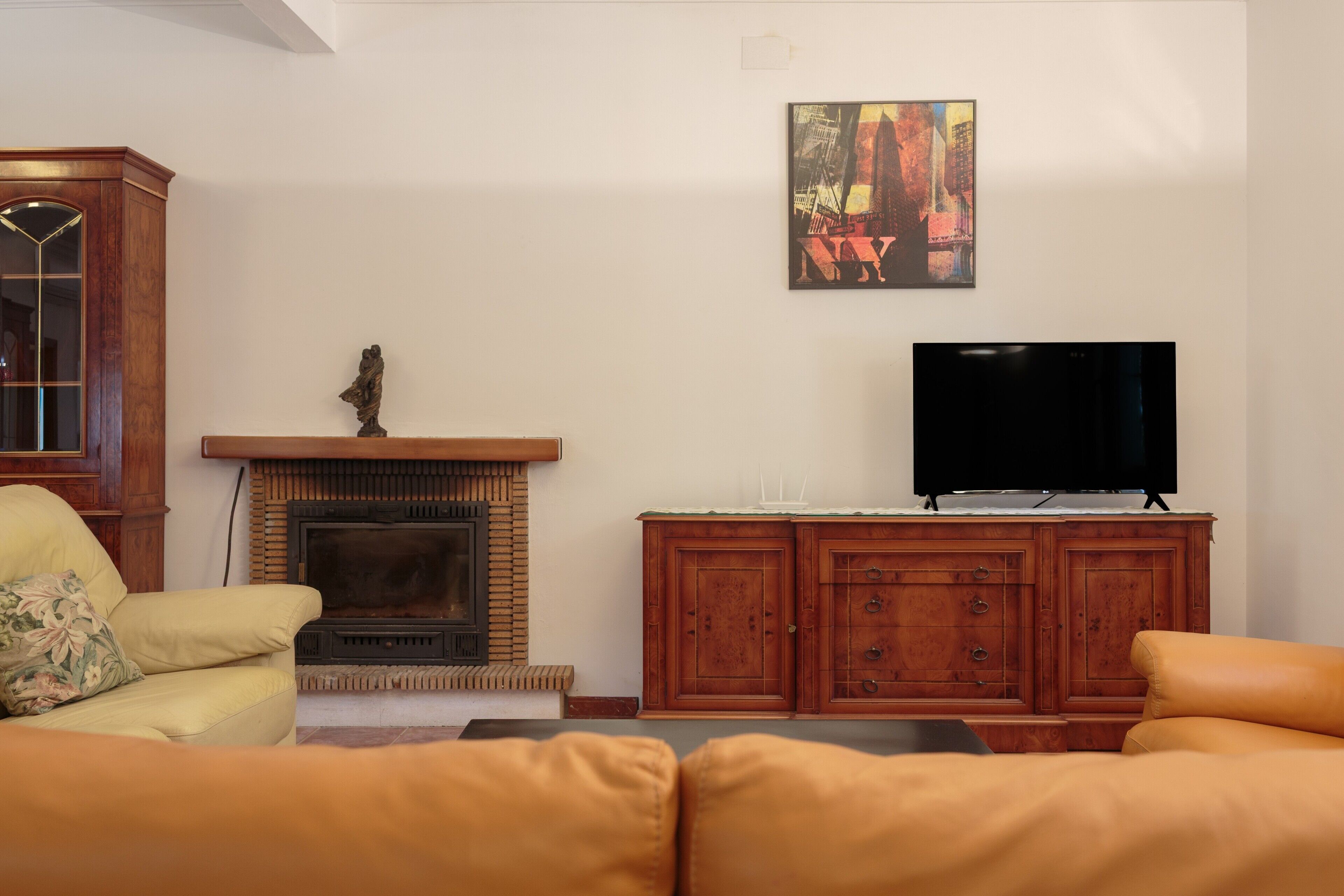 Una sala de estar con chimenea, televisor y muebles de madera.