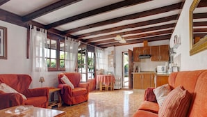 Une pièce avec un plafond en bois, un canapé, une table et un coin cuisine.