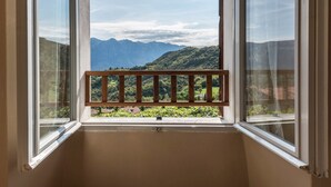 Une pièce avec une fenêtre donnant sur un paysage montagneux.