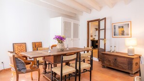A dining area with a wooden table, wicker chairs, a cabinet, and a framed picture on the wall. - Vacation Home 'Casa Max' with Landmark View, Private Pool, Terrace & Wi-Fi (Arta)