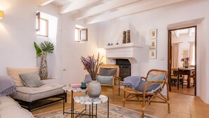 A living room with a sofa, chairs, a fireplace, a table with a vase, and a patterned rug. - Vacation Home 'Casa Max' with Landmark View, Private Pool, Terrace & Wi-Fi (Arta)