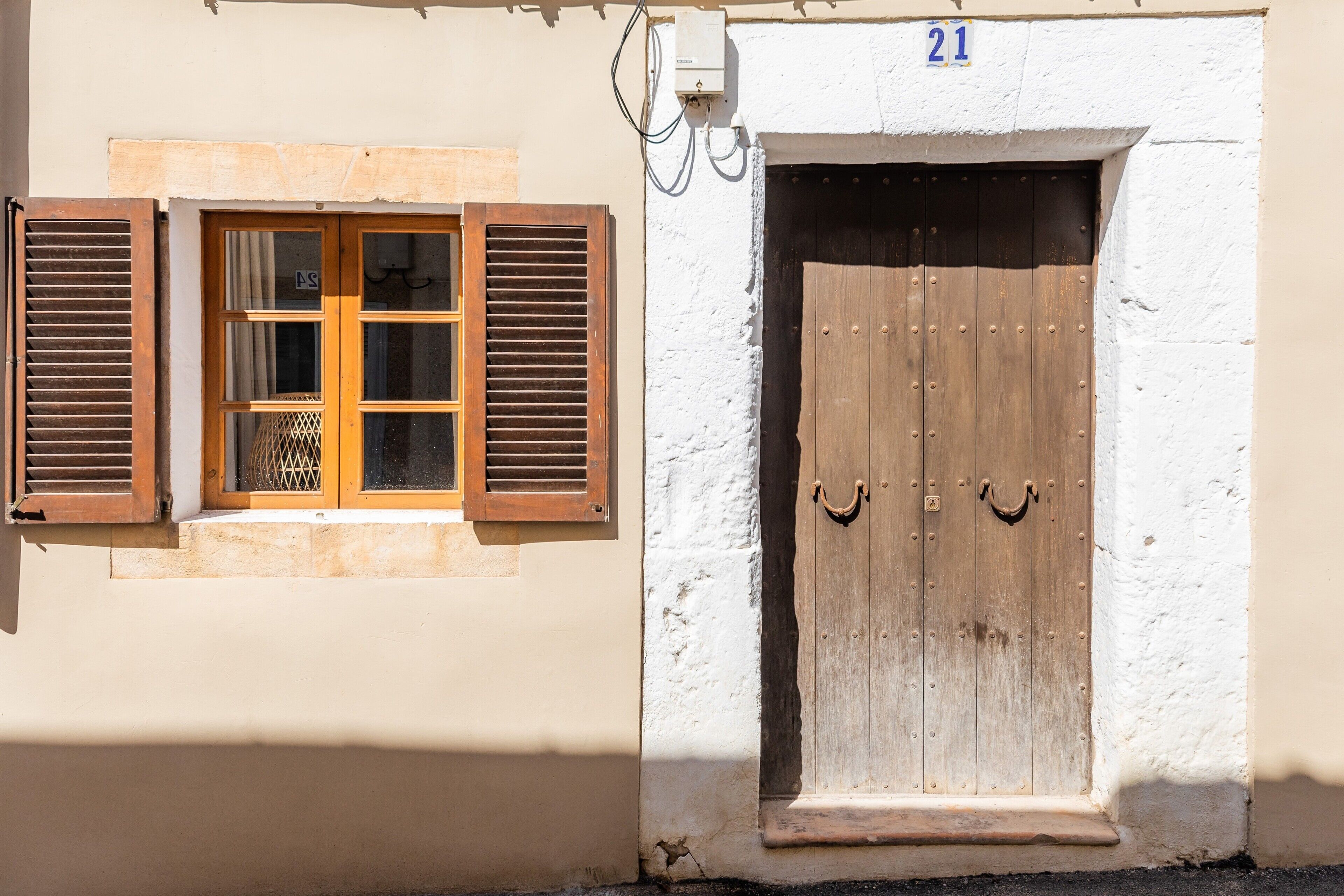 A building with a wooden door and a window with shutters.