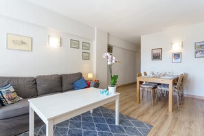 Un salon moderne avec un canapé, une table à manger pour quatre personnes et une table basse.