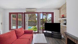 Una sala de estar con un sofá rojo, un televisor y una chimenea.