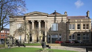 A building with classical architecture, including columns and a symmetrical facade, viewed from an apartment balcony. - Heart of Macclesfield 2 Bedroom Grade II Apartment (Macclesfield)