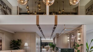 A spacious lobby with a high ceiling, modern pendant lighting, a central seating area, and a reception desk. - Delita City Hotel (Istanbul)