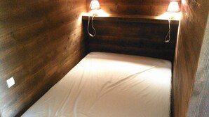 Una cama litera de madera con dos lámparas de noche.