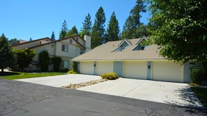 A two-story residential building with a garage, a driveway, and a well-maintained lawn.