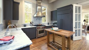 Una cocina moderna con armarios oscuros, una isla grande, una estufa y un microondas.