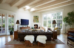 A spacious living room with a large leather sofa, a flat-screen TV, and a fireplace. - SANTA FE IN ITS  NATURAL STATE (Santa Fe)