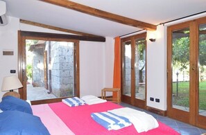 Une chambre à coucher avec un lit, une chaise et une vue sur l’extérieur.