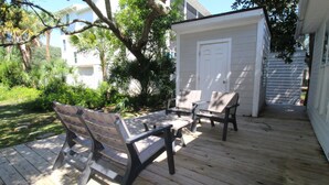 Eine Holzterrasse mit zwei Bänken und einem kleinen Schuppen.