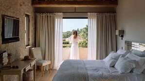A bedroom with a bed, a desk, a chair, and a view of a balcony with curtains. - Heated pool, Outdoor cinema, Spa Terrace, Stroll to Shops, luxury equipped (Mougins)